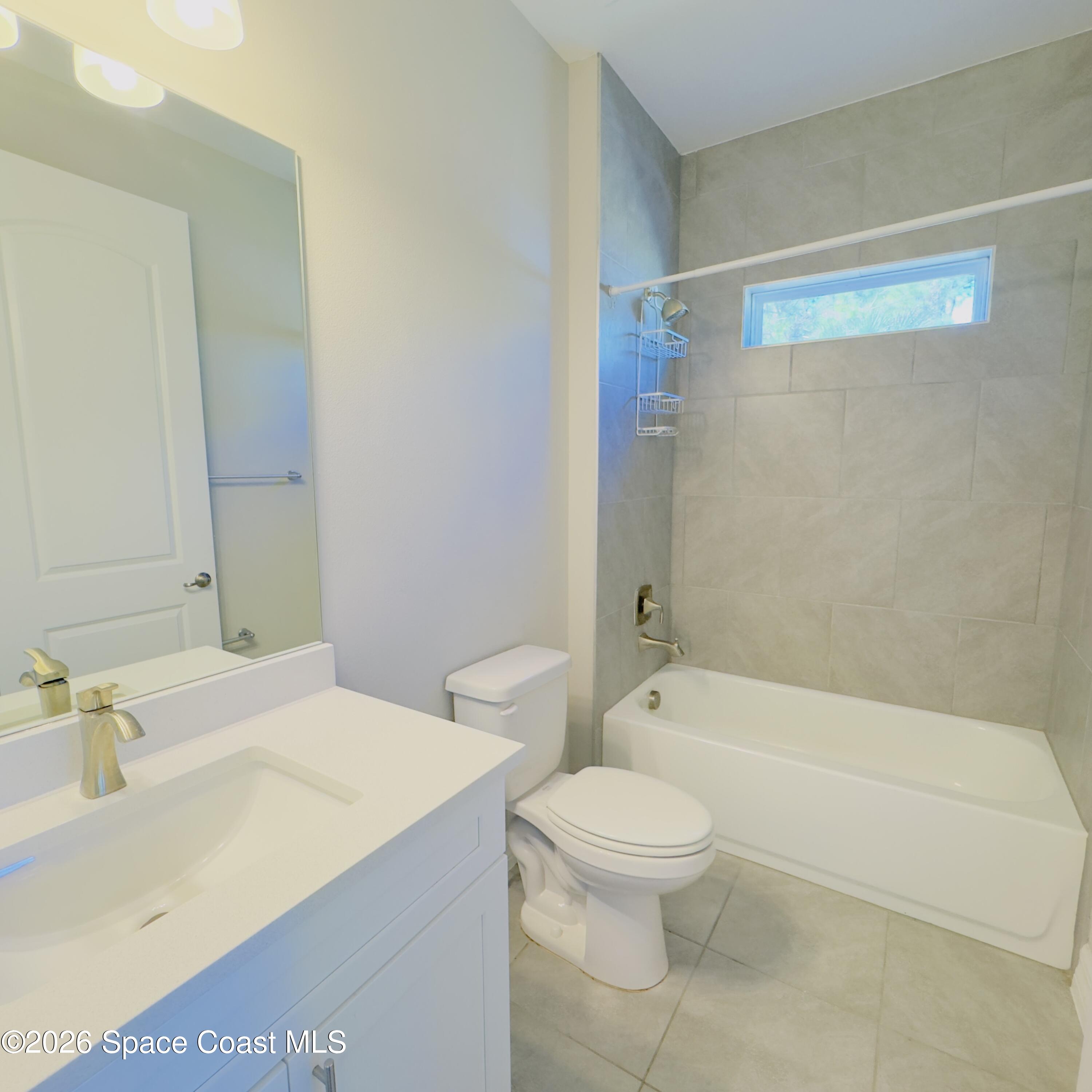 1376 Torgerson Road Southeast Palm Bay, FL 32909 - Photo 8 of 15 a bathroom with a sink a toilet and a bathtub