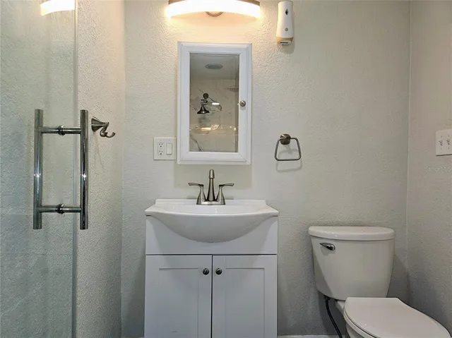 a bathroom with a sink a toilet and mirror