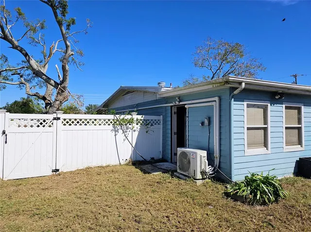 a view of a house with a small yard and potted plants