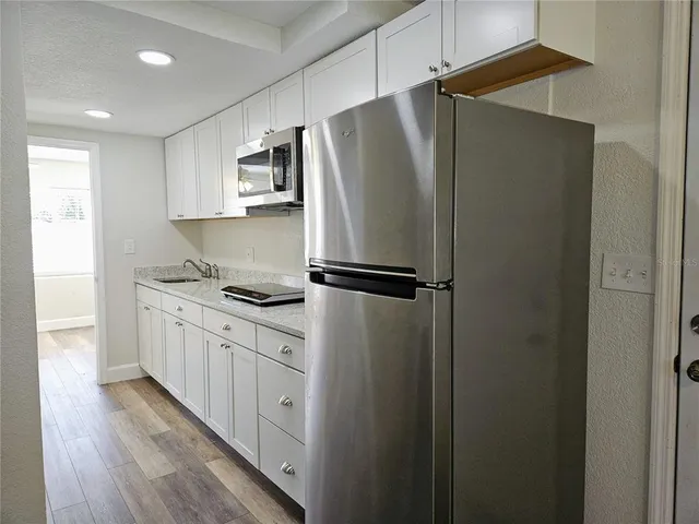 a kitchen with stainless steel appliances granite countertop a refrigerator and a sink
