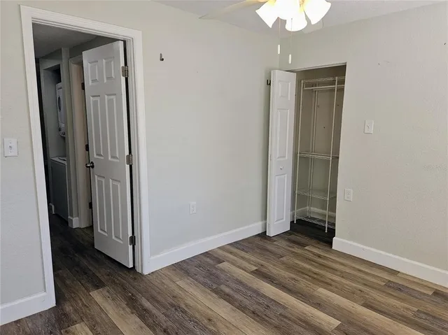 a view of a room with wooden floor and a ceiling fan