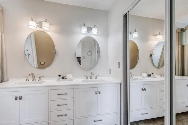 a bathroom with double vanity sinks and a mirror