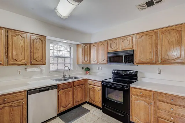 a kitchen with granite countertop a sink stainless steel appliances and cabinets