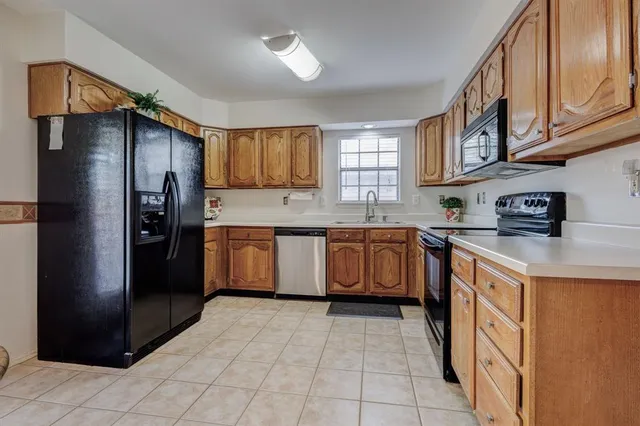 a kitchen with a sink refrigerator and cabinets