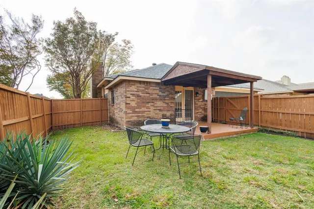 a view of a chair and table in backyard of the house