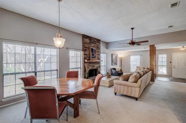 a living room with fireplace furniture and a large window