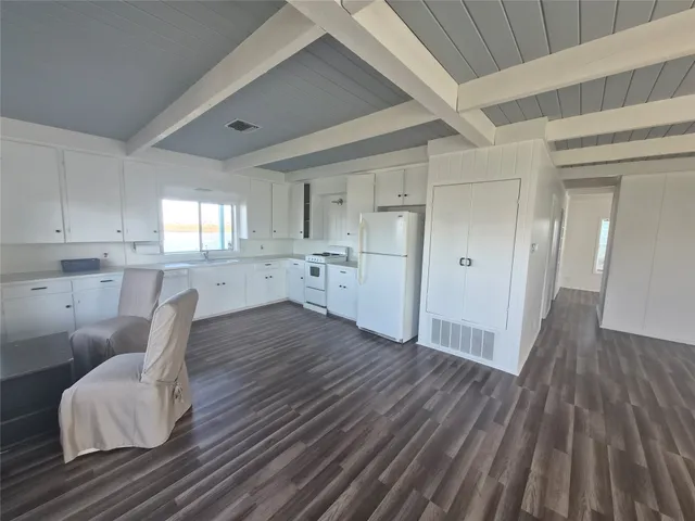a kitchen with wooden floors and white cabinets