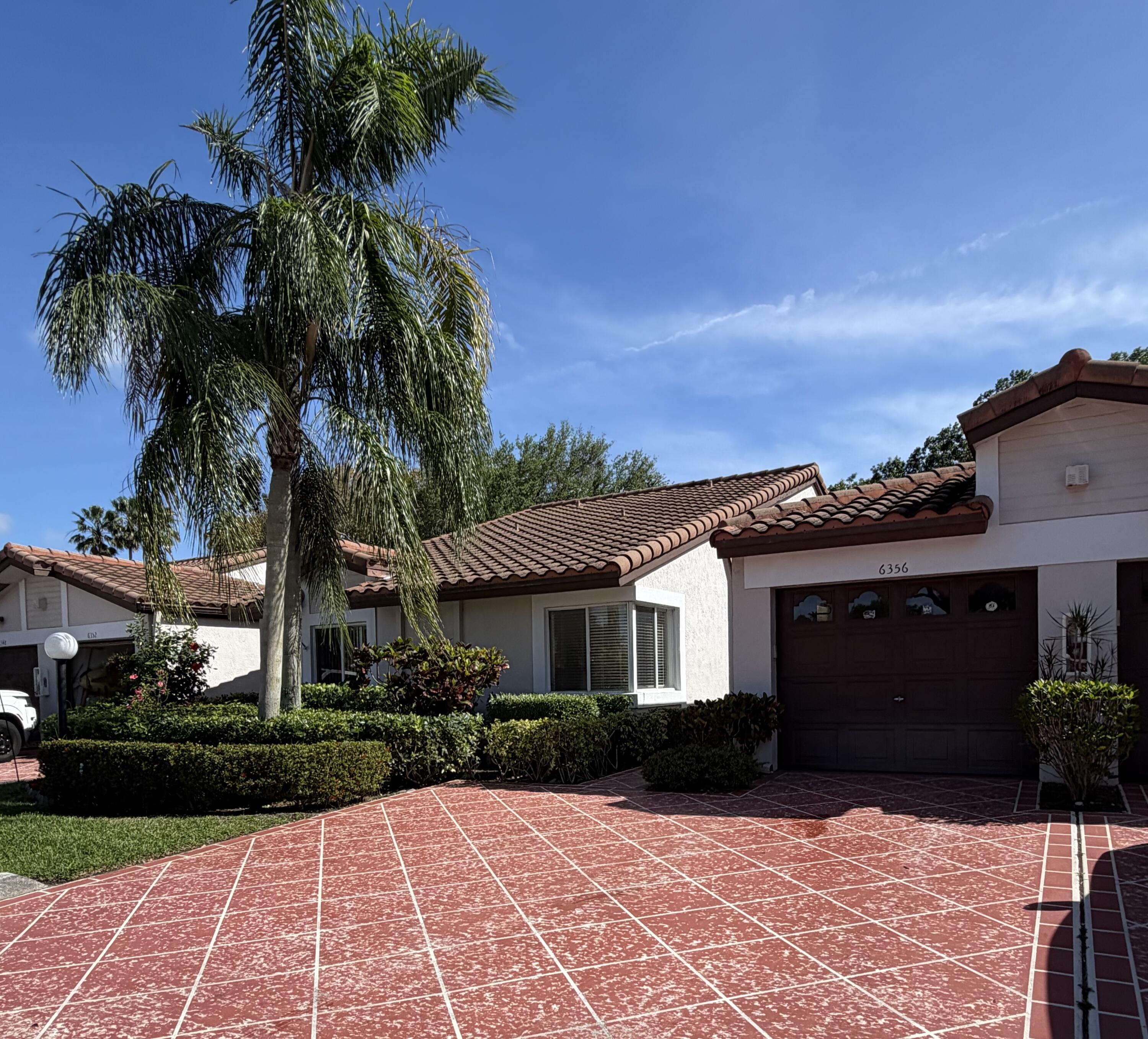 6356 Pointe Pleasant Circle, Unit G Delray Beach, FL 33484 - Photo 1 of 31 a front view of a house with a garden