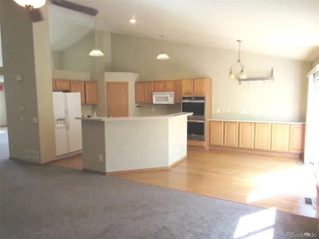a view of kitchen with kitchen island and stainless steel appliances