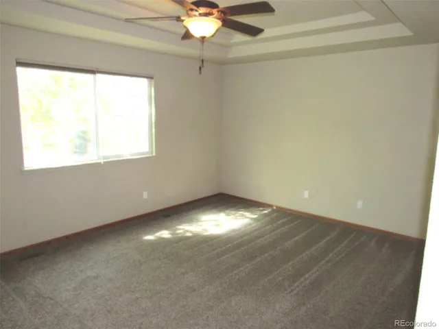an empty room with a fan and a window