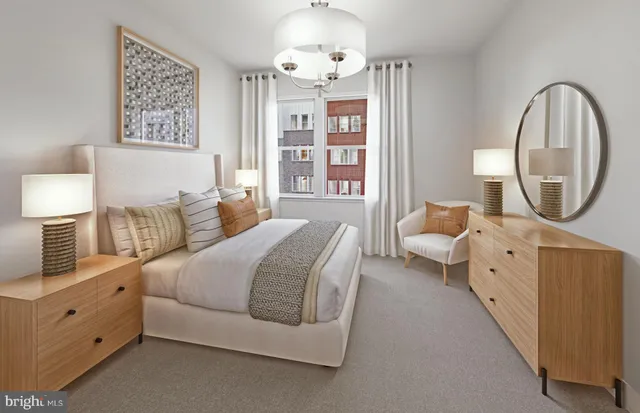 a spacious bedroom with a bed a mirror and a large window