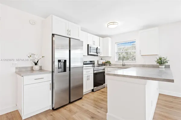 a kitchen with a refrigerator sink and cabinets