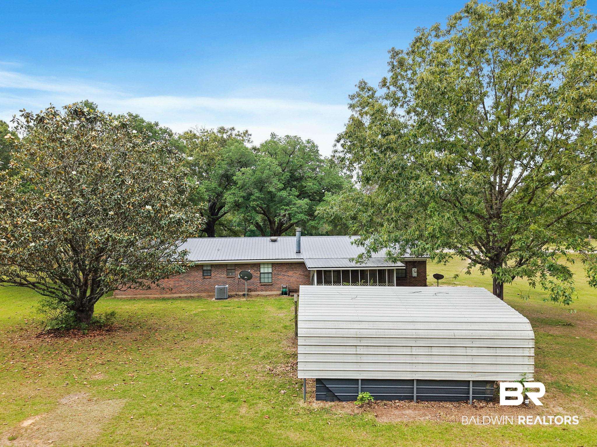 13653 Roberts Road Loxley, AL 36551 - Photo 28 of 33 Spacious grounds featuring a brick exterior home with a metal roof, screened porch, and mature trees