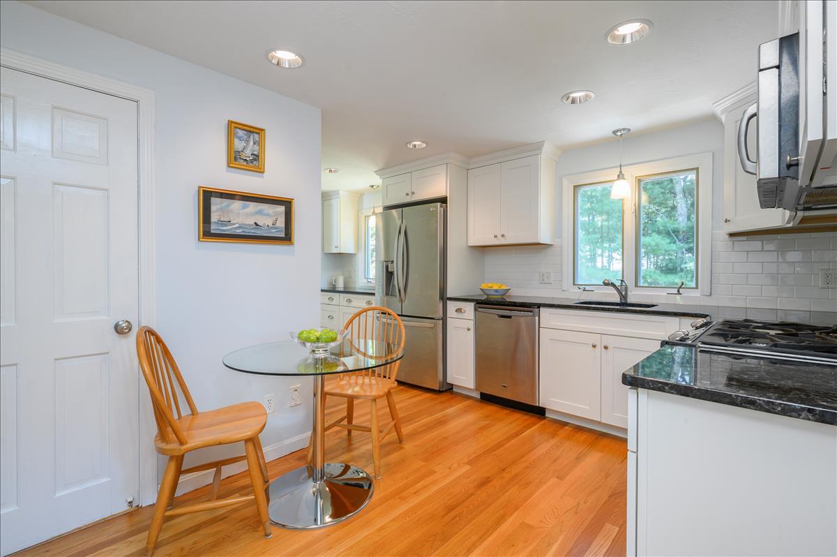 218 Hickory Hill Circle Osterville, MA 02655 - Photo 9 of 30 a kitchen with stainless steel appliances granite countertop a stove a sink a refrigerator dining table and chairs