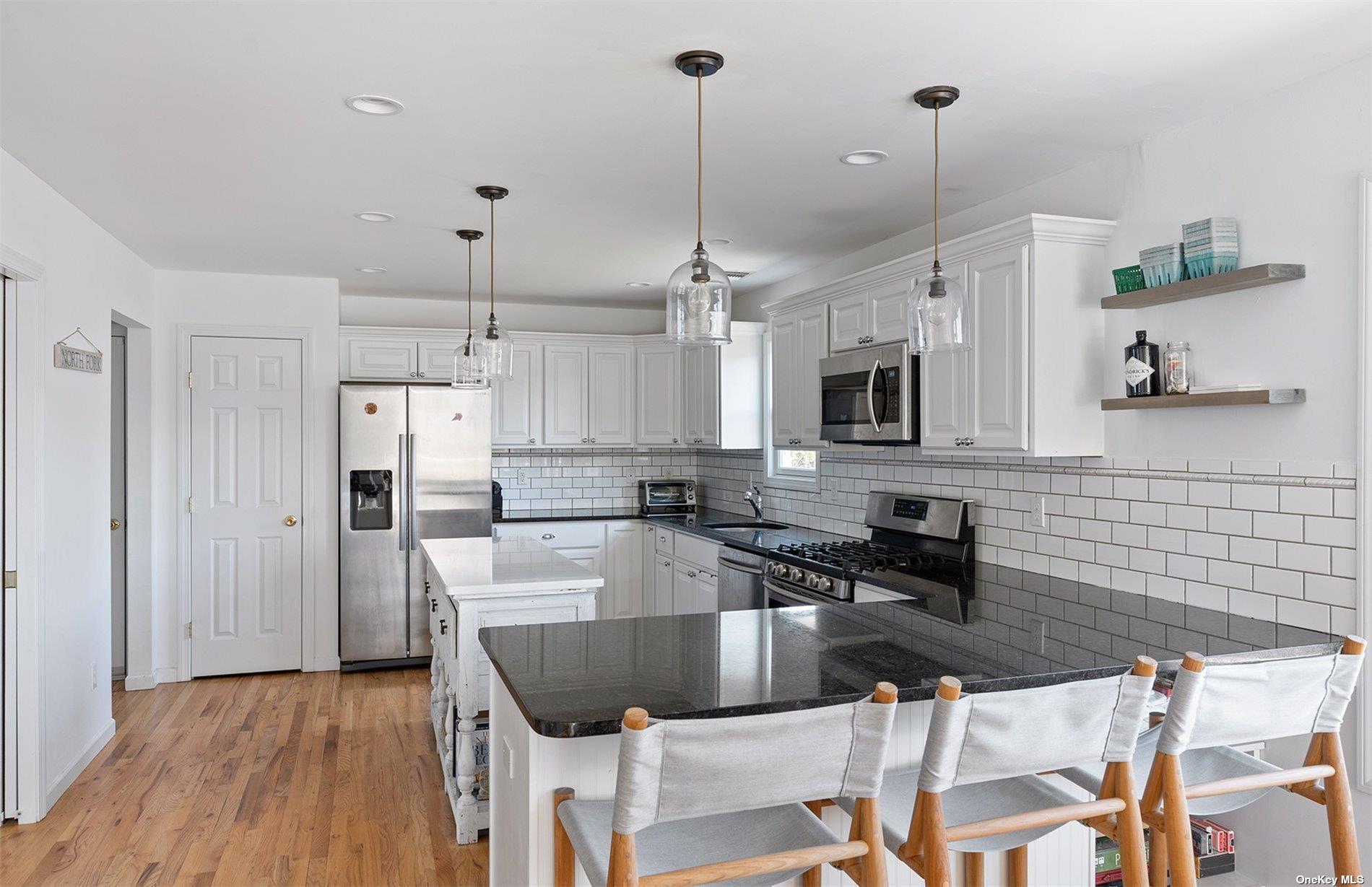 355 Midway Road Southold, NY 11971 - Photo 10 of 24 a kitchen with stainless steel appliances granite countertop a sink a stove and a refrigerator