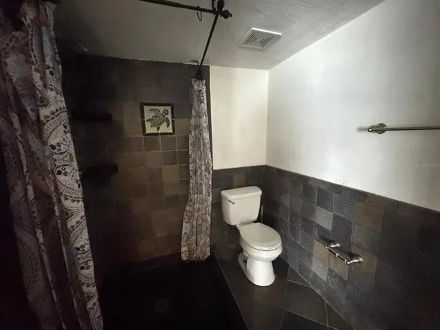 a bathroom with a toilet and a shower
