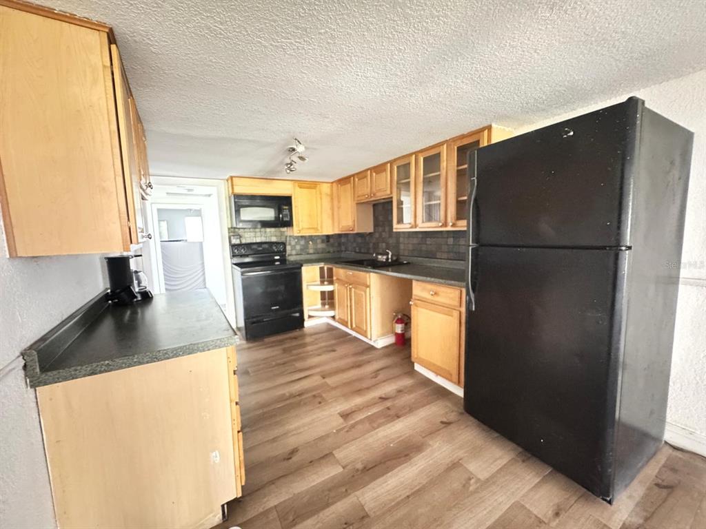 224 10th Avenue Ocoee, FL 34761 - Photo 5 of 14 a kitchen with stainless steel appliances granite countertop a refrigerator a stove and a sink with wooden floors