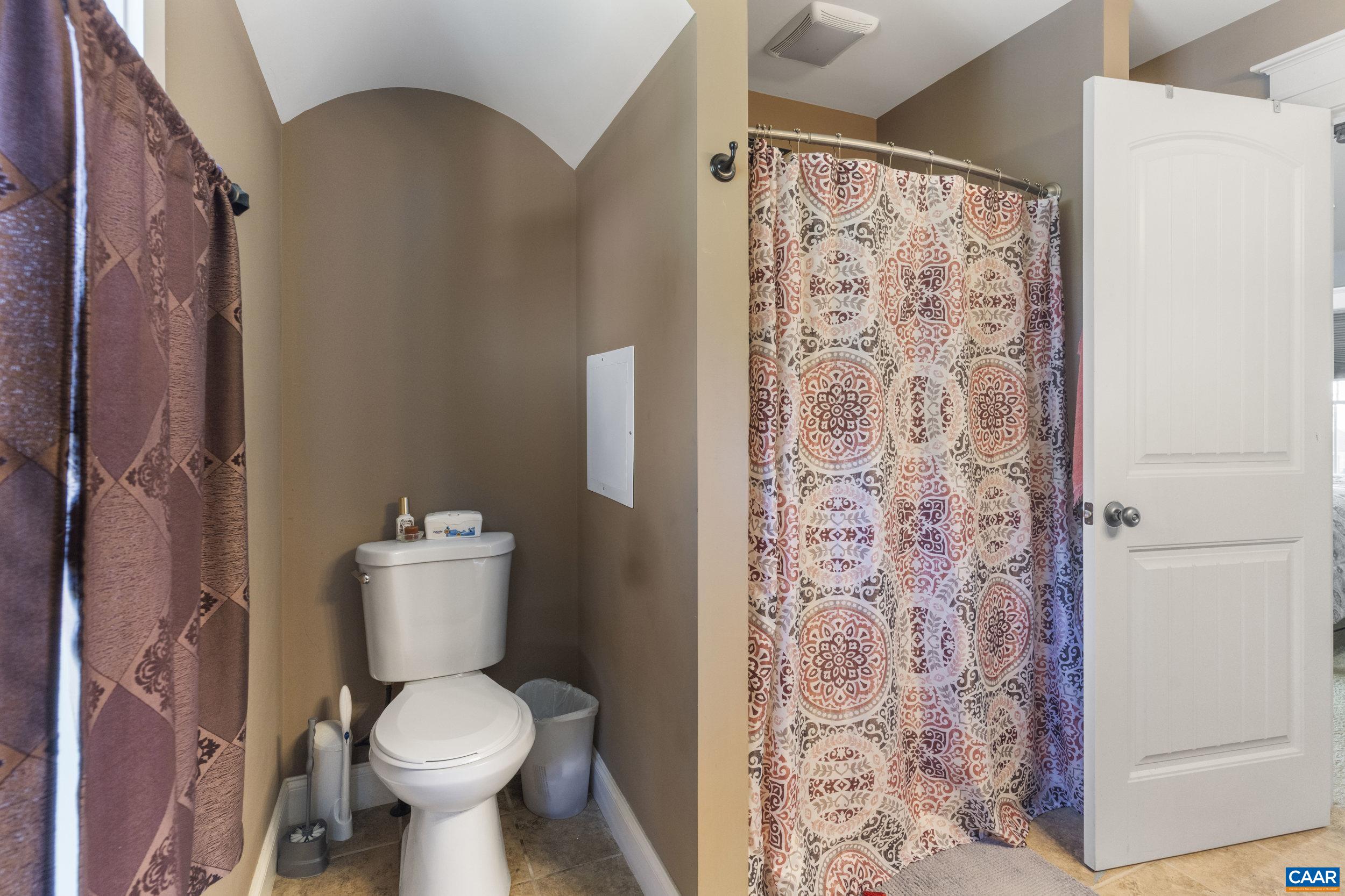 379 Crestview Drive Rustburg, VA 24588 - Photo 26 of 53 a white toilet sitting next to a shower curtain