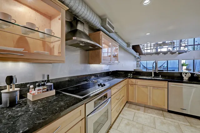 a kitchen with stainless steel appliances granite countertop a sink and cabinets