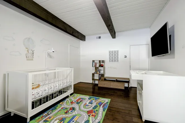 a bedroom with furniture and flat screen tv