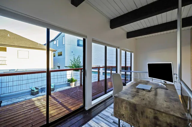 a bedroom with a bed and large window with balcony view