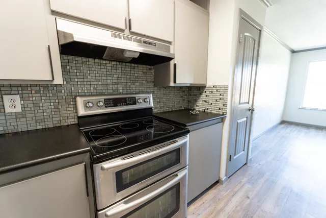 a kitchen with wooden cabinets and a stove top oven
