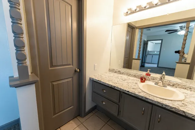 a bathroom with a granite countertop sink and a mirror