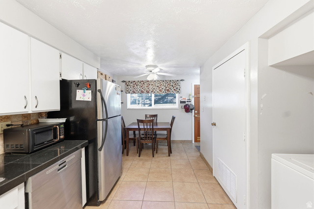 314 West Center Street, Unit F102 Bountiful, UT 84010 - Photo 16 of 29 Kitchen featuring tile flooring, white cabinetry, dark countertops, and a window with natural light