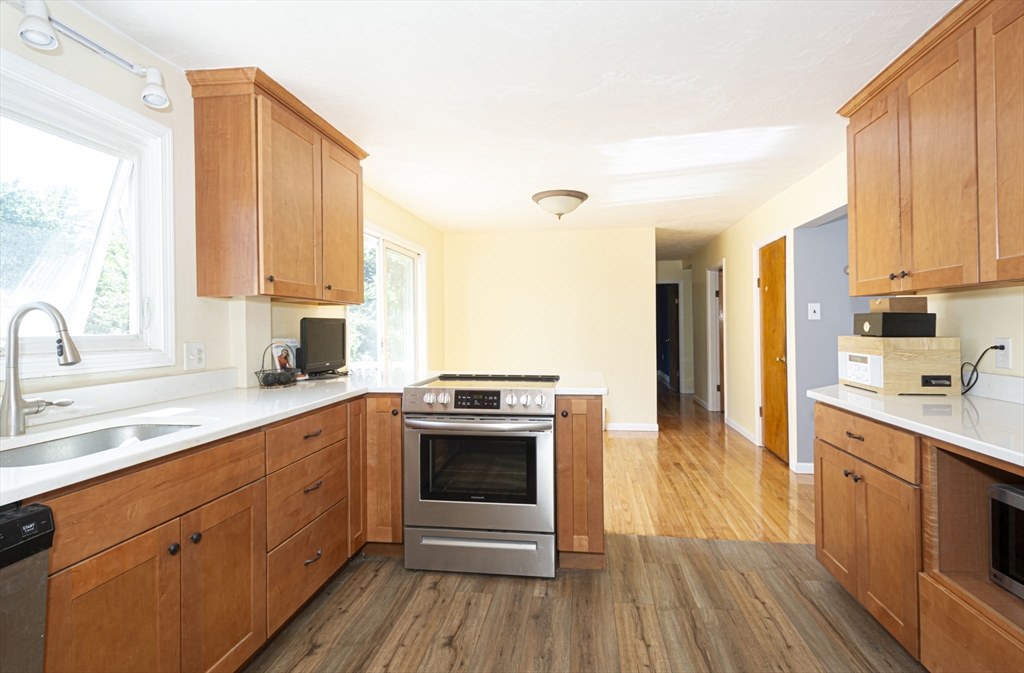 107 Ponakin Road Lancaster, MA 01523 - Photo 21 of 33 a kitchen with stainless steel appliances granite countertop a stove a sink dishwasher and a refrigerator with wooden floor