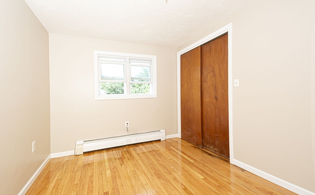 107 Ponakin Road Lancaster, MA 01523 - Photo 29 of 33 a view of an empty room with wooden floor and a window