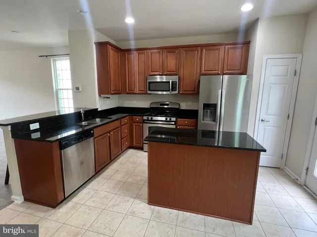a kitchen with stainless steel appliances granite countertop a stove a refrigerator and a sink