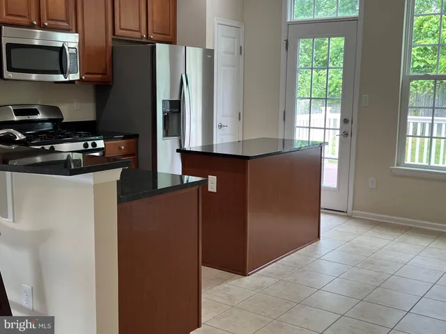 a kitchen with stainless steel appliances granite countertop a refrigerator and a stove