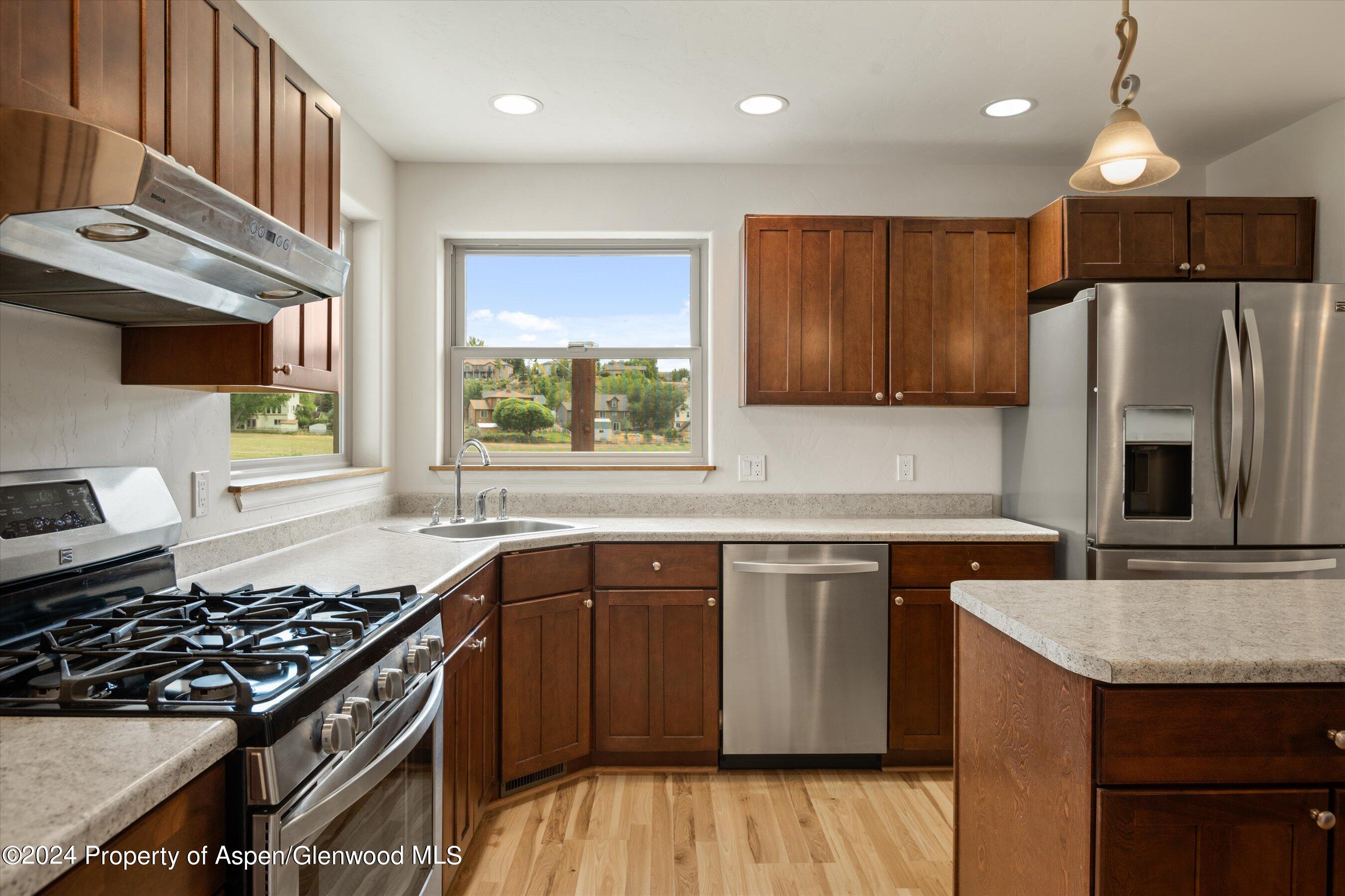 1095 East 16th Street Rifle, CO 81650 - Photo 4 of 43 a kitchen with stainless steel appliances granite countertop a stove a sink dishwasher and a refrigerator