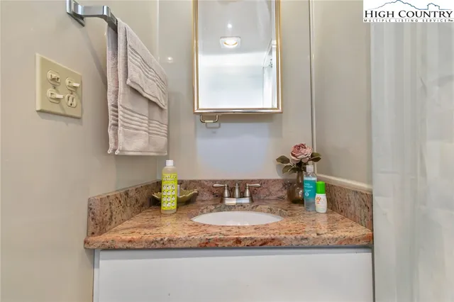 a bathroom with a granite countertop sink and a mirror