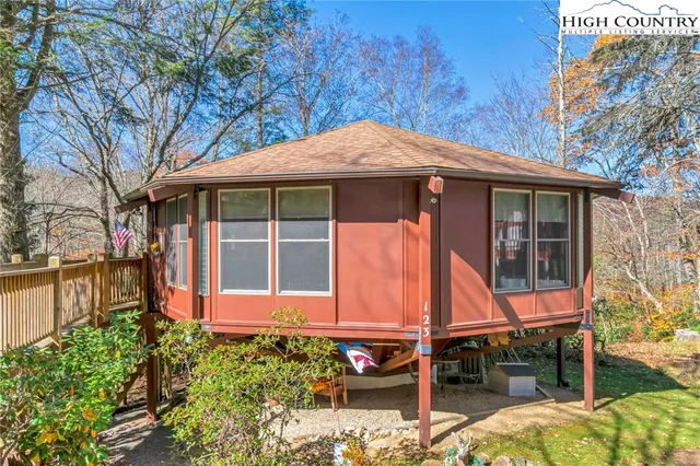 a backyard of a house with table and chairs large wooden floor and fence