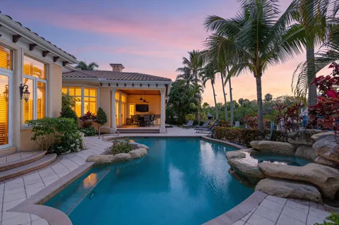 a view of a house with a small yard and palm trees