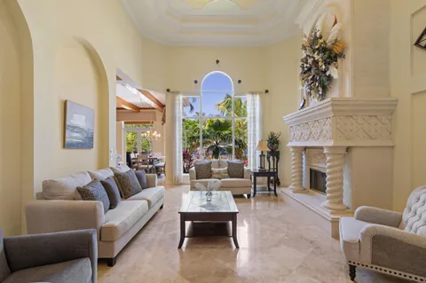 a living room with furniture a fireplace and a chandelier