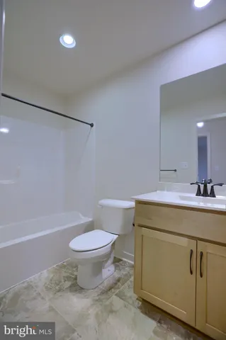 a bathroom with a granite countertop toilet a sink and a mirror