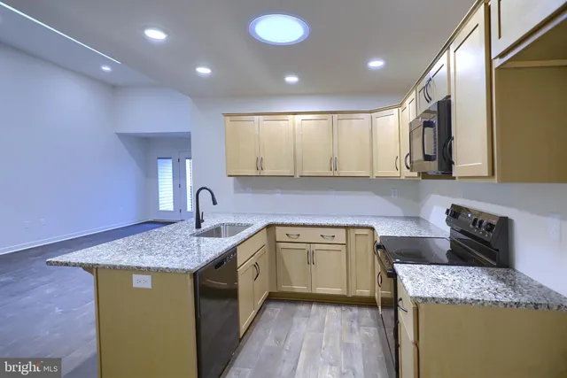 a kitchen with a sink a stove and cabinets