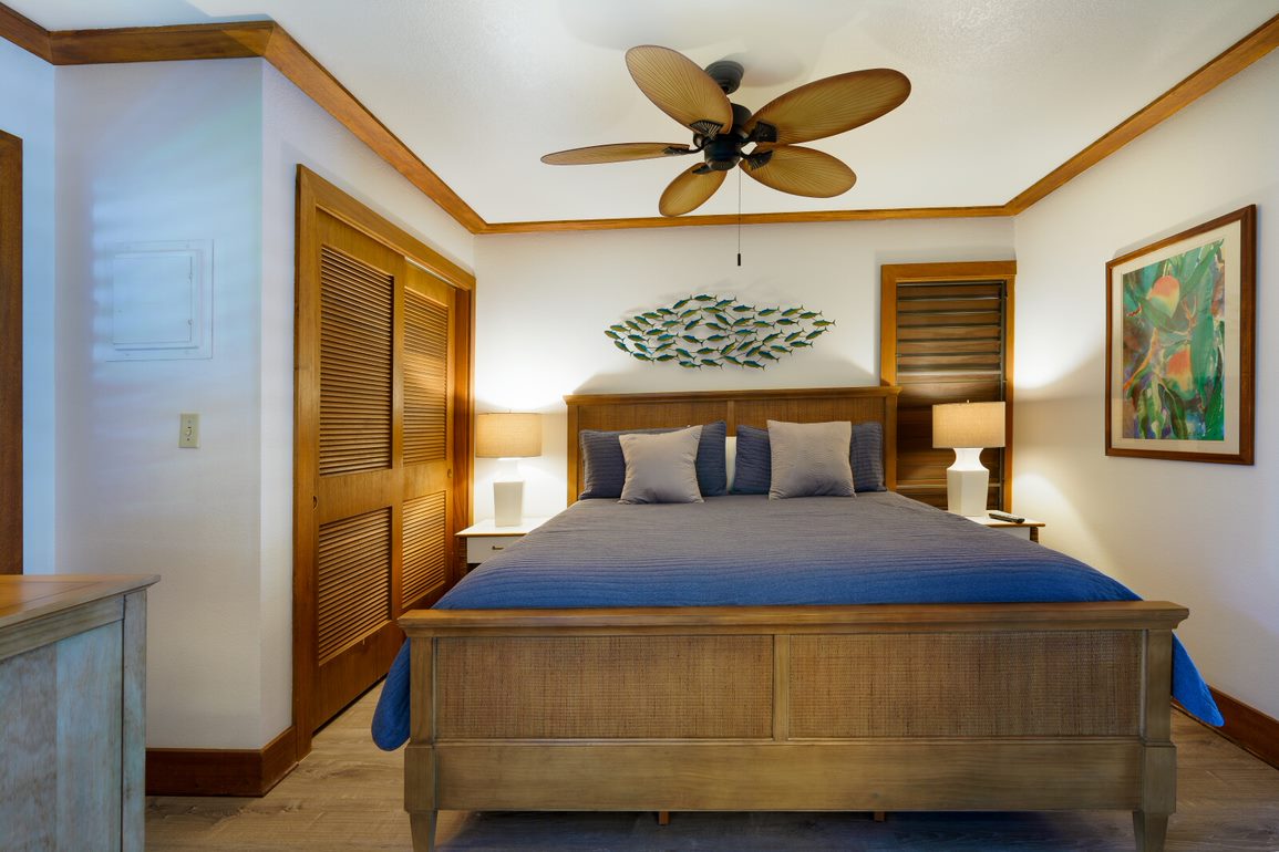 2253 Poipu Road, Unit 407 Koloa, HI 96756 - Photo 7 of 8 a bedroom with a bed and a chandelier