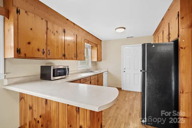 a kitchen with stainless steel appliances granite countertop a refrigerator a stove and a sink