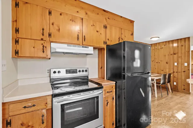 a kitchen with stainless steel appliances granite countertop a refrigerator stove and sink