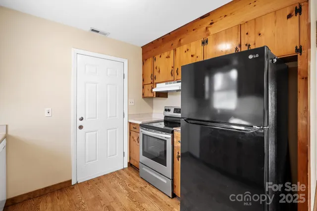 a kitchen with stainless steel appliances granite countertop a refrigerator and a stove top oven