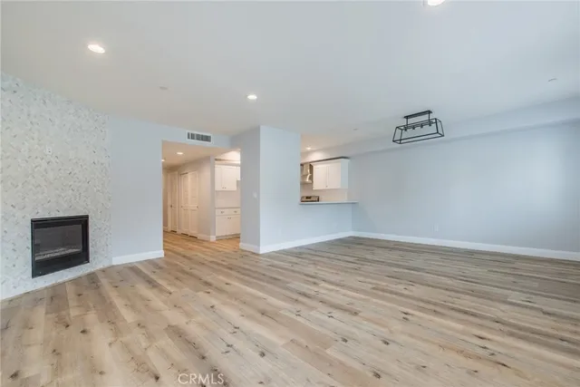 a view of empty room with wooden floor and fireplace