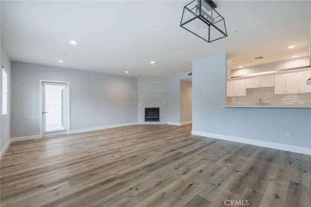 a view of empty room with wooden floor and windows