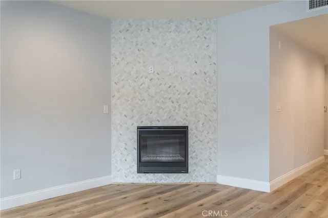 a room with a wooden floor and a fireplace