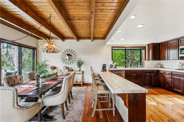 a kitchen with stainless steel appliances granite countertop a refrigerator a stove and a sink with wooden floors