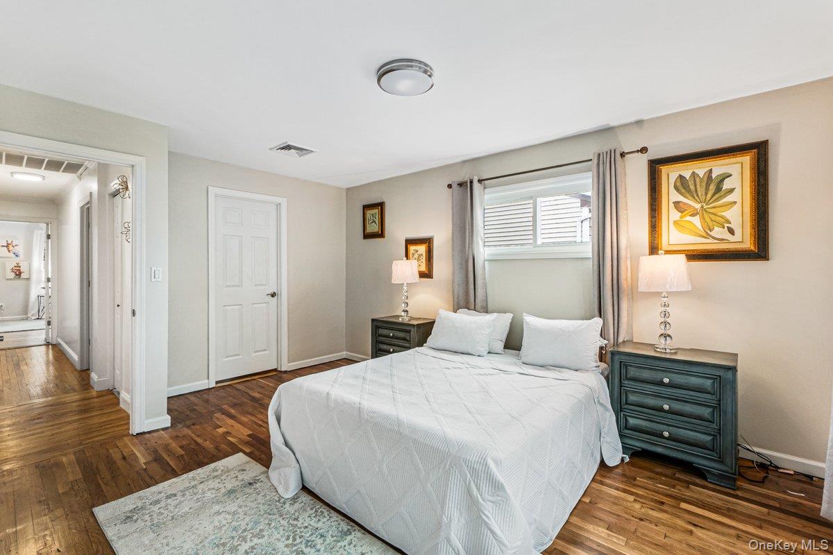 5 Terry Lane Plainview, NY 11803 - Photo 13 of 29 a bedroom with a bed and wooden floor