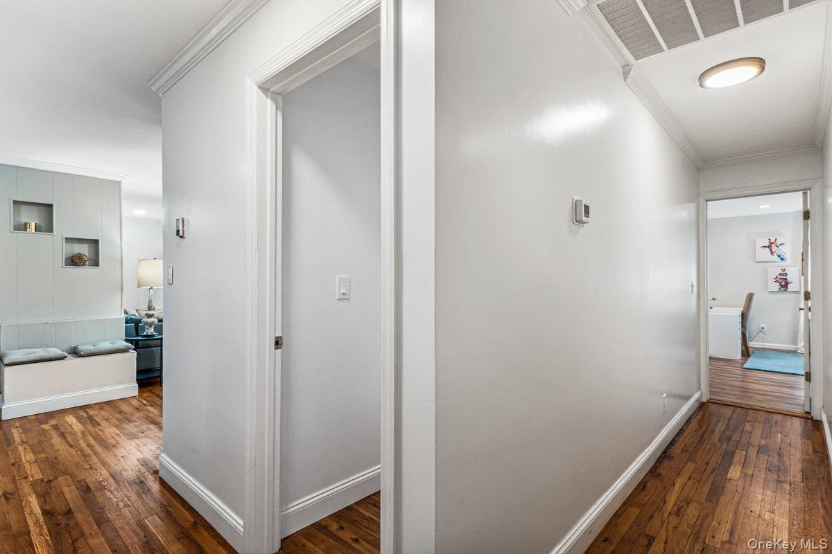 5 Terry Lane Plainview, NY 11803 - Photo 16 of 29 a view of a hallway with wooden floor and a bathroom
