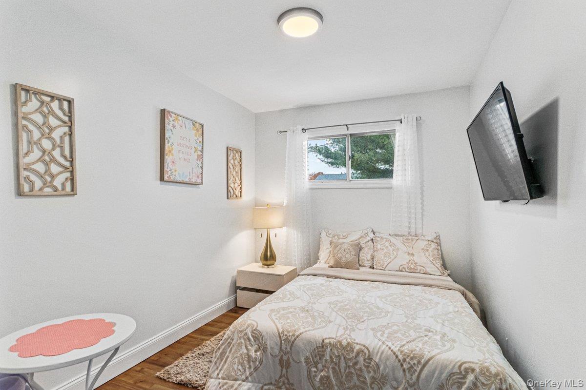 5 Terry Lane Plainview, NY 11803 - Photo 18 of 29 a bedroom with a bed and a flat screen tv